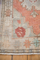 Geometric starburst border and distressed pile of vintage Oushak rug in terracotta and silver.