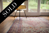 Worn Kerman rug showing faded pink, blue, gold floral motifs and unique birds.