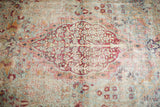 Worn vintage Kerman rug, light blue and dark pink floral medallion with bird motifs.
