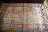Kerman rug's faded blue and pink floral border with ivory field.