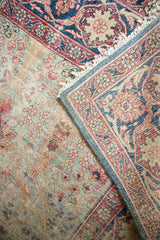 Aesthetically worn Kerman rug with light blue floral field and bold dark blue border.