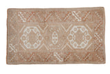 Hand-knotted distressed Melas rug with geometric medallion guls and serrated border in pale coffee and copper.