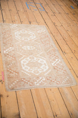 Hand-knotted distressed Melas rug, showing even wear to knot heads and soft ivory hues.