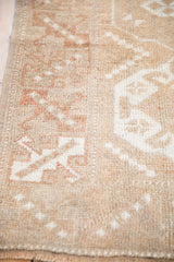 Worn texture of the distressed Melas rug, showing ivory geometric patterns and intact side selvage.