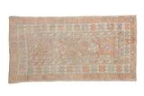 Vintage distressed Oushak rug with a floral pattern in dusty rose, seafoam green, and ivory tones.