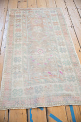 Full length view of the distressed vintage Oushak rug, highlighting its time-softened floral design.