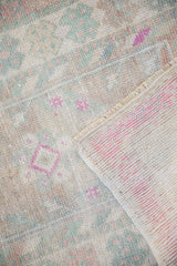 Folded corner of the vintage Oushak rug showing its low, worn pile and hand-knotted foundation.