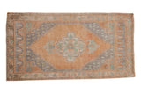 Distressed Oushak rug featuring a faded orange field, slate blue medallion, and mint green motifs.