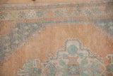 Vintage distressed Oushak rug detail, highlighting worn dusty sandalwood field and stepped slate blue motif.