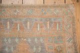 Distressed vintage Oushak corner with fringe, sandalwood, and slate blue stepped patterns.