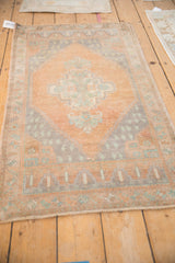 Distressed Oushak rug corner detail, showing stepped niche and meandering vine border with muted colors.