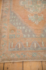 Distressed vintage Turkish Oushak rug corner, with stepped end and meandering vine border.