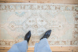 Distressed vintage Oushak runner: faded central medallion, geometric florals, in soft beige and seafoam.