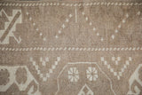 Close-up: Distressed hand-knotted Turkish Melas rug with oxidized silver geometric pattern.