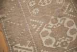 Distressed Melas rug detail showing hook and latch patterns with serrated edges and muted tones.