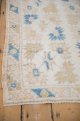 Distressed Dosemealti rug close-up: shaggy pile texture, ivory field with blue floral designs.