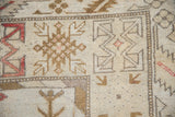 Distressed ivory and ochre patterned pile of a Vintage Melas rug.