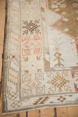 Distressed Melas rug pile texture with visible foundation, geometric arrow motifs, and muted red.