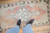 Distressed Oushak runner with heavy abrashes, even wear, and blush, slate blue motifs.