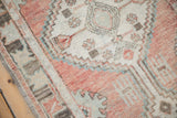 Distressed texture and geometric floral motifs in dusty blush and oxidized silver on a vintage Oushak runner.