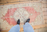 A view from above showing the distressed texture and scale of a vintage Oushak rug runner.