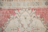 Low knot-heads and distressed texture on a vintage Oushak in faded cherry red and ivory.