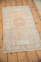 Distressed Oushak runner from an angle, showing the octagonal medallion and muted floral border.