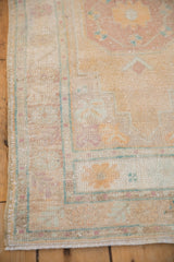Close-up of the stepped corner spandrel on a distressed Oushak rug with even wear.