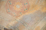 Folded corner of a vintage Oushak reveals its low pile and hand-knotted foundation.