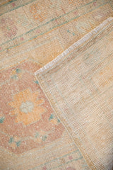 The hand-knotted reverse and distressed pile of a vintage Turkish Oushak rug.