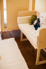 White maple sidecar bench demonstrating its fit alongside a bed frame.