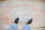 Distressed Oushak runner with faded terracotta, dusty mint, and ivory geometric motifs.