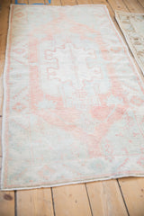 Distressed Oushak rug runner end, with worn pile, faint foundation, and soft terracotta, mint tones.