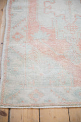 Low pile and even wear of vintage Oushak runner with muted terracotta and mint patterns.