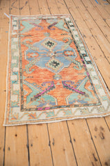 Corner of vintage Oushak runner, abrashed rust field, faded turquoise spandrel, and minor serpent border.
