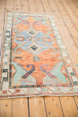 Abrashed terracotta field of vintage Oushak rug, with faded blue medallion and magenta vines.