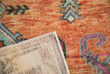 Low pile of vintage Oushak rug with rust, turquoise, magenta pattern, showing its ivory foundation.