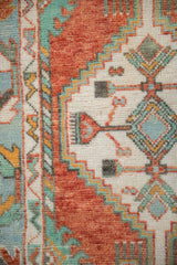 Detail of the vintage Oushak rug's stepped geometric design in rust, turquoise, saffron yellow, and ivory.