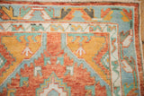 Stepped corner spandrel and floral border of a vintage Oushak rug in rust and turquoise.