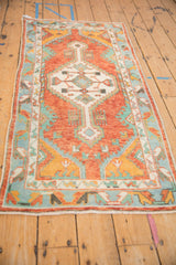Angled perspective of the vintage Oushak runner, showcasing its rust field and turquoise geometric border.