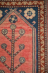 Oushak rug detail: blush field, blue tree of life motif, and meandering red border.
