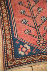 Turkish Oushak rug corner, meandering blue vine border and blush field's simplistic blossoms.
