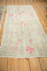 Angled view of the vintage Oushak runner showing its full length, distressed texture, and soft colors.