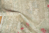 Softly draped vintage Oushak rug showing its low, distressed pile and hand-knotted texture.