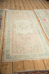 Distressed Oushak runner detail: dusty rose field, subtle germinating plant and cloudband motifs.