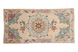 Vintage distressed Oushak runner, starburst medallion, ivory field, faded pastel floral motifs. 2'11