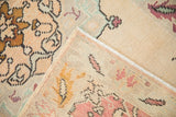 Distressed Oushak rug pile in blush, mint, aubergine floral motifs; visible hand-knotted back.