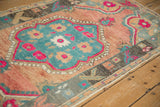 Angled view of a distressed Oushak rug highlighting its worn pile and floral medallion.