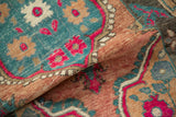 The soft, pliable texture of a distressed Oushak rug with pops of fuchsia and dusty teal.