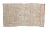 Vintage Oushak rug with a distressed, faded medallion in pale rose and soft sea foam green.